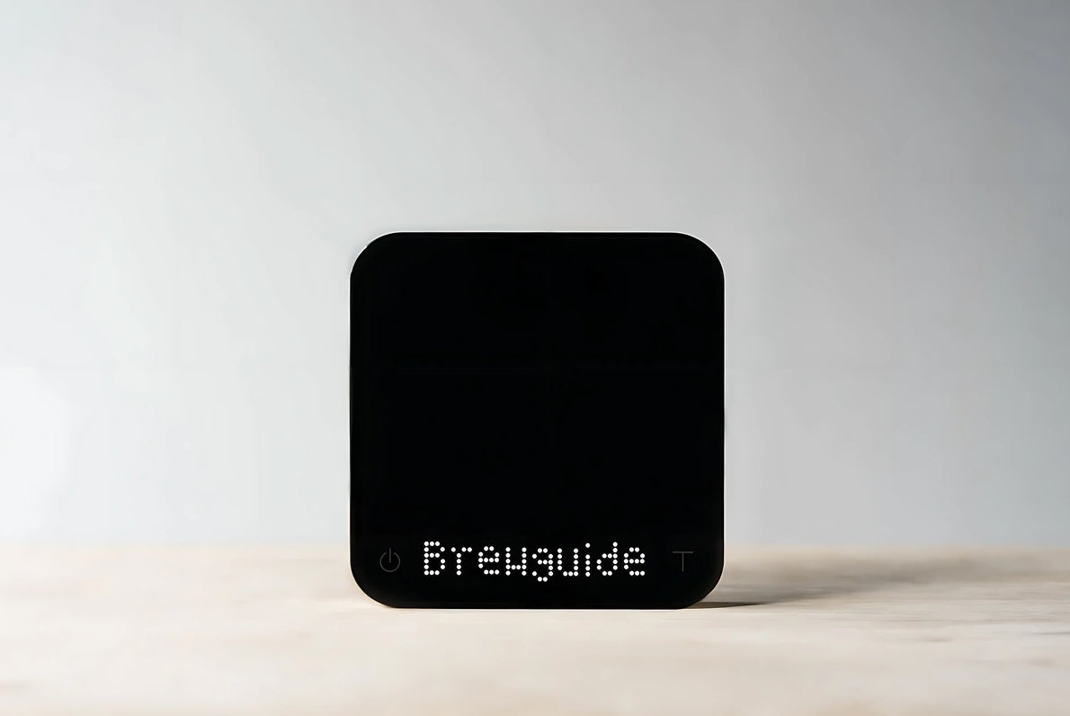 Acaia Pearl S coffee scale with LED display showing "Brewguide," sleek black design.