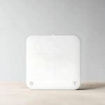 Acaia New Pearl coffee scale in white on a neutral background.
