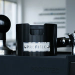 Profitec Tamperstation in black anodized aluminum with tamper and portafilter.