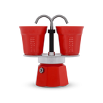 Bialetti Mini Express espresso maker with two red ceramic cups.